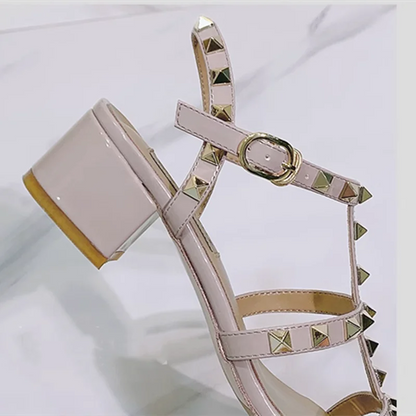 These British women's elegant low-heeled sandals feature a matte/shiny finish, front open toes, lock studs, and buckle T-straps available in fuchsia or beige leather